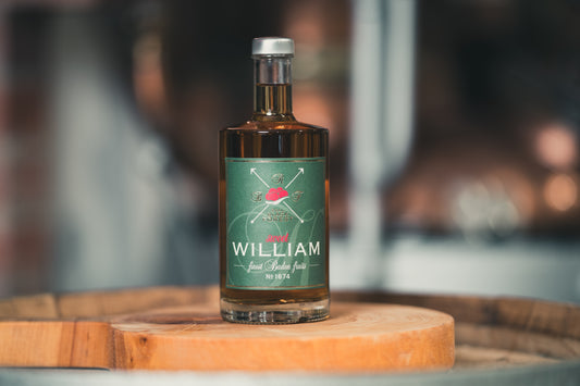 Sweet William Schnaps auf einem Holzfass mit Schnapsglas von RealBlackForest für milderen Genuss