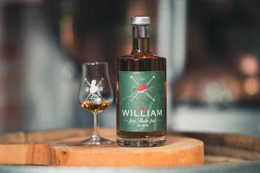 Sweet William Schnaps auf einem Holzfass mit Schnapsglas von RealBlackForest für milderen Genuss